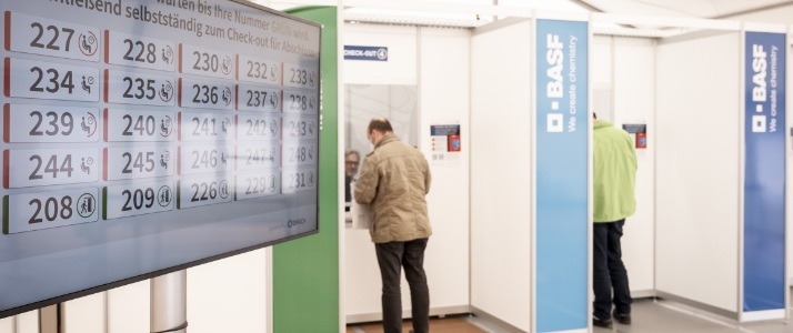 Beschäftigte erhalten eine Wartenummer für ihren Impftermin bei der BASF