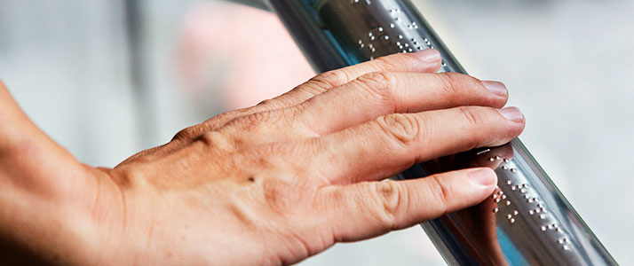 Eine Hand ertastes auf einem eisernen Griff taktile Informationen.
