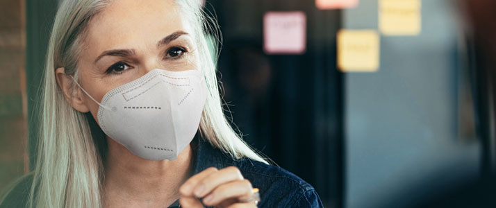 Eine weibliche Führungsperson mit FFP2-Maske.