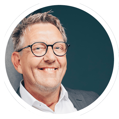 Porträtfoto von Michael Schmitz, Leiter des Fachbereichs Abfallmanagement des Universitätsklinikums Bonn. Er hat kurze, helle Haare, trägt eine Brille und grinst in die Kamera.