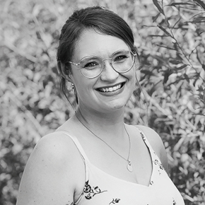 Julia Zimmermann trägt ein Kleid und hat eine Brille auf.