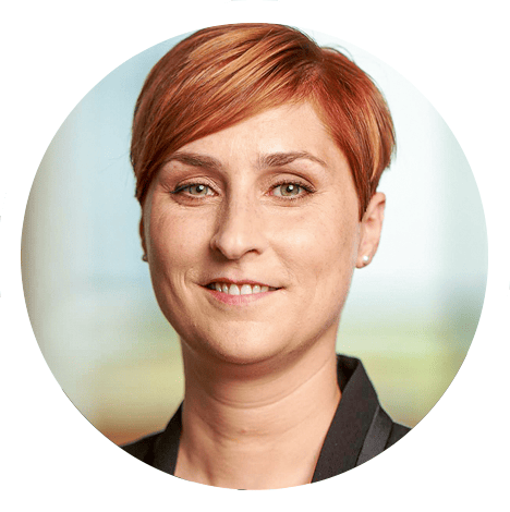 Portraitfoto von Anne Gehrke, Diplom-Psychologin und Referentin am Institut für Arbeit und Gesundheit der Deutschen Gesetzlichen Unfallversicherung (IAG). Sie hat rote, kurze Haar und lächelt.